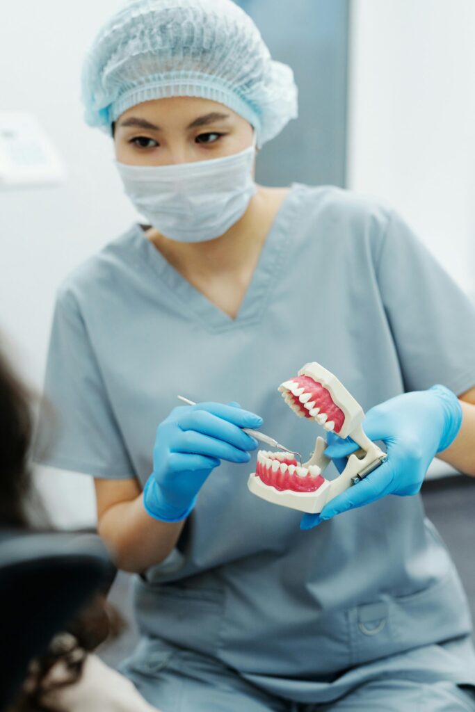A dental professional explaining a treatment procedure using a realistic denture model at Dental Clinic 24 Antalya.