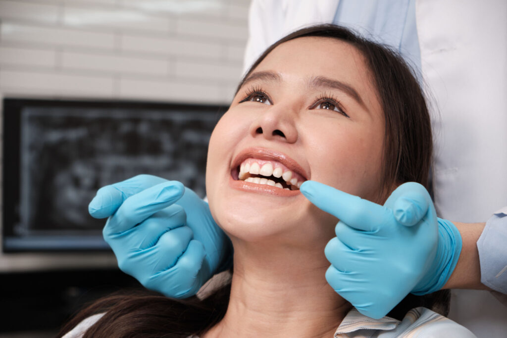 A happy female patient smiling and showing her white teeth during a dental checkup at Dental Clinic 24 Antalya.